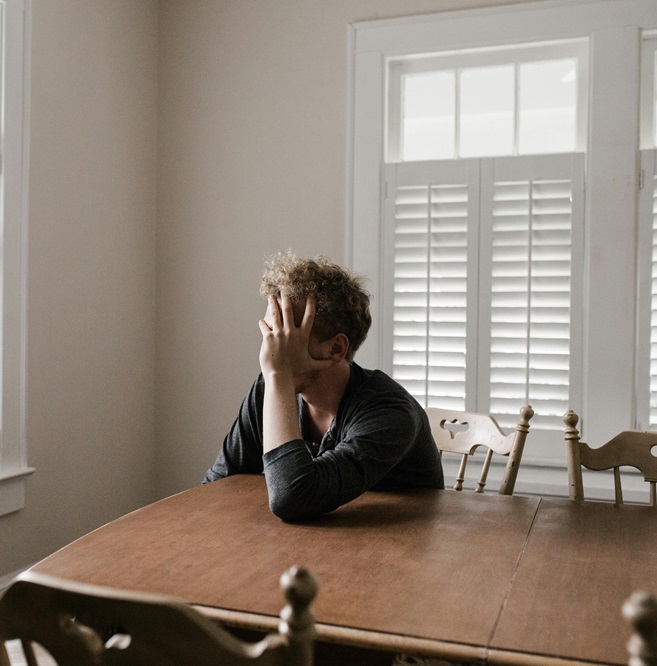 Person sitting alone looking overwhelmed, reflecting the need for anxiety therapy.